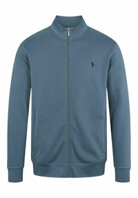 Veste bleue à fermeture éclair intégrale avec col montant, manches longues, deux poches latérales et petit logo brodé sur la poitrine gauche.