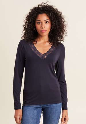 Marineblauwe langemouwen top met een V-halslijn versierd met kantdetails. Gemaakt van een soepele stof voor een comfortabele pasvorm.