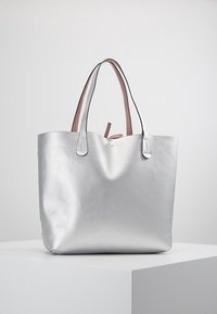 Zilveren tote bag met een gladde metallic afwerking, voorzien van roze leren handgrepen en een minimalistisch ontwerp. Stevig met een open bovenkant.