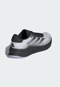 Sportlicher Sneaker mit einem Obermaterial aus Mesh in Weiß und Grau, schwarzen Akzenten, einer gepolsterten Sohle und drei Streifen-Logos an der Seite.
