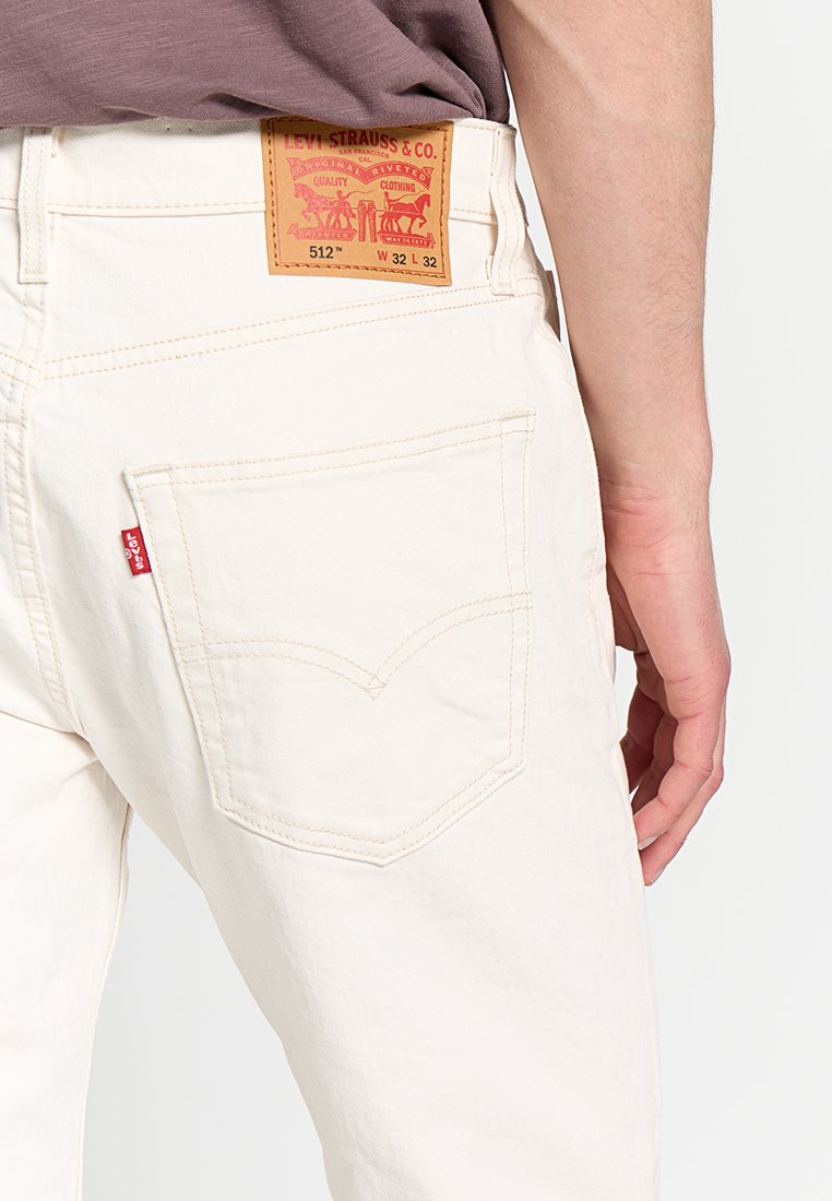 Weiße Denim-Jeans mit klassischem Design. Verfügt über eine Gesäßtasche mit einer geschwungenen Naht und einem Leder-Logo-Patch am Bund.