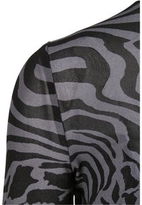 Czarny i szary wzorzysty sweter z dzianiny w designie w paski zebry, teksturowany materiał, okrągły dekolt, zbliżenie na obszar ramienia.