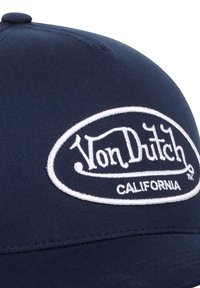 Casquette de baseball navy avec une couronne arrondie, présentant un logo "Von Dutch" brodé en blanc et le texte "CALIFORNIA" dans un design ovale.