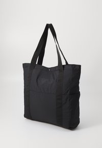 Borsa tote nera realizzata in un tessuto leggero con doppi manici neri. Presenta un corpo spazioso e un dettaglio con tasca frontale.