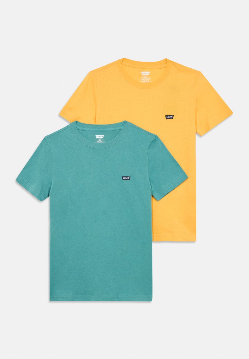 Δύο βαμβακερά t-shirt: ένα τιρκουάζ και ένα κίτρινο, και τα δύο με λαιμόκοψη crew, κοντά μανίκια και ένα μικρό μαύρο λογότυπο μάρκας στο στήθος.