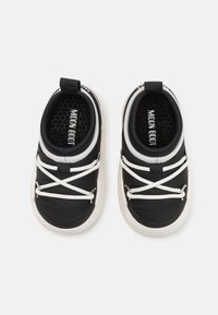 Scarpe in tessuto nero con lacci bianchi, suole in gomma e un sistema di estrazione. Presentano una soletta testurizzata e il marchio "MOON BOOT" all'interno.