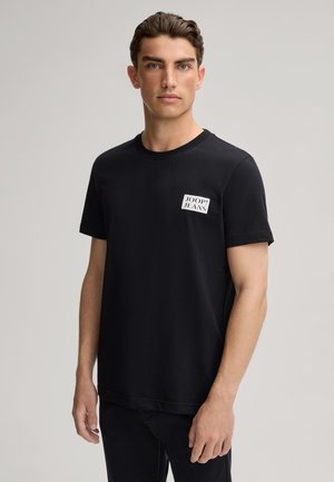 Black cotton t-shirt featuring a round neckline, short sleeves, and a front pocket with a white logo label reading "JOOP! JEANS."