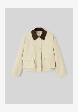 Veste courte beige avec col en velours côtelé marron, boutons-pression à l'avant et deux grandes poches à rabat avec fermeture par bouton-pression.