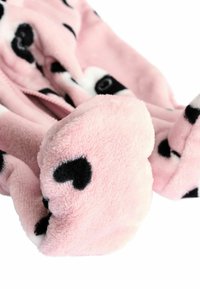 Jasnoróżowy materiał polarowy w czarne serca i wzory w kropki; charakteryzuje się miękką teksturą i zaokrąglonymi krawędziami. Podkreślenie puszystości.