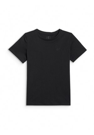 Młoda dziewczyna z długimi czarnymi włosami, ubrana w czarny t-shirt, czarne legginsy, białe sneakersy, białe skarpetki, fioletową bluzę zawiązaną w pasie i różową torbę na ramię.