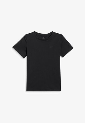 Młoda dziewczyna z długimi czarnymi włosami, ubrana w czarny t-shirt, czarne legginsy, białe sneakersy, białe skarpetki, fioletową bluzę zawiązaną w pasie i różową torbę na ramię.
