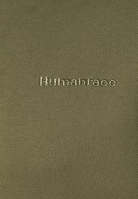 Olive green fabric featuring smooth texture, with the word "Humanrace" embroidered in a contrasting light beige thread.