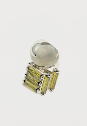Anillo de plata con una parte superior grande y redondeada y un conjunto de piedras preciosas rectangulares verticales de color amarillo verdoso, sujetas con garras de plata.