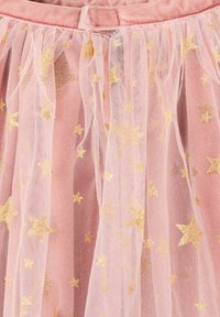 Fustă roz cu o bază din țesătură moale și un overlay de tull stratificat, împodobită cu motive de stele aurii pe toată suprafața. Închidere la talie.