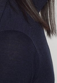 Námořnický pletený svetr s přiléhavým střihem, hladkou texturou a švy na rameni. Měkká tkanina, lehký vzhled.