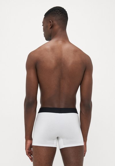 Hvide boxer briefs med en sort elastisk talje, lavet af glat stof, der fremviser et simpelt design og tætsiddende pasform.