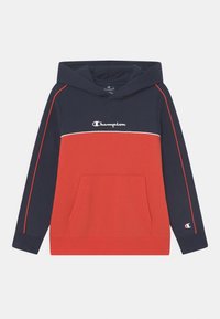 Sudadera Champion que presenta un top de color azul marino con acentos rojos y un bolsillo frontal. Incluye un logo en el pecho y detalles de costura en contraste.