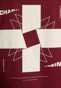 Fond bordeaux avec une grande croix blanche entourée de lignes géométriques abstraites et de textes incluant "Laboratoire de recherche" et "C-Community".