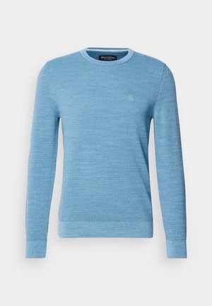 Helles blaues Strickpullover mit rundem Ausschnitt, langen Ärmeln und gerippte Bündchen. Verfügt über ein dezentes Logo auf der Brust. Weiche Textur.