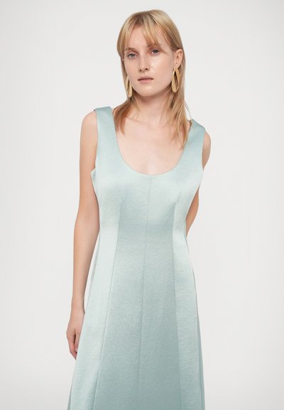 Un vestito senza maniche di un azzurro leggero con scollo rotondo, caratterizzato da un tessuto testurizzato e una silhouette svasata con cuciture verticali.