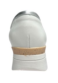 Chaussure en cuir blanc avec des finitions argentées, dotée d'un intermédiaire en liège tacheté beige et d'une semelle blanche texturée, vue de l'arrière.