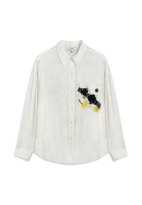 Chemise blanche texturée avec col, manches longues et une poche plaquée ornée d'appliqués floraux noirs et jaunes ainsi que d'accents en dentelle.