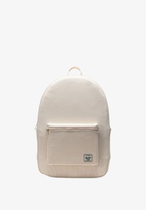 Sac à dos en toile beige avec un haut arrondi, une poche zippée à l'avant et un patch logo en bas. Tissu robuste et bretelles ajustables.