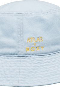 Lichtblauwe bucket hat van stof met een textuurafwerking. Bevat gele geborduurde branding: "ATLAS x ROXY" aan de zijkant.