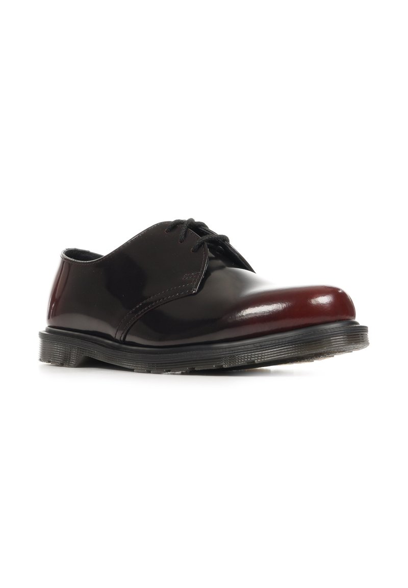 Schwarzer und dunkelroter polierter Lederschnürschuh mit dicker schwarzer Sohle, in einem Winkel vor weißem Hintergrund gezeigt.