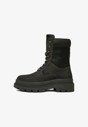 Černá vojenská obuv na tkaničky s tlustou podrážkou, polstrovaným límcem u kotníku a svrchním dílem z kombinace kůže a textilu, zobrazená z boku.