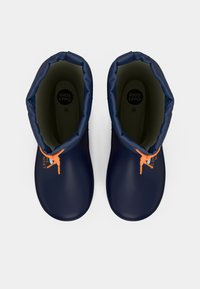 Par de botas impermeables azul marino con cuellos acolchados y cordones naranjas, vistas desde arriba sobre un fondo blanco.