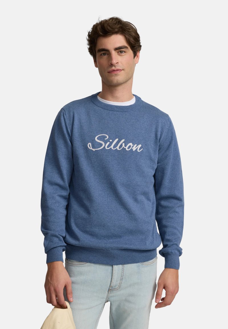 Sudadera azul de cuello redondo con una textura suave y un logo bordado en blanco de "Silbon" en el pecho. Puños y dobladillo acanalados.
