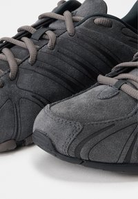 Γκρι σουέτ αθλητικά παπούτσια με υφή, επίπεδα κορδόνια και καουτσούκ σόλα. Διαθέτουν μαλακό κολάρο και ενισχυμένη περιοχή δαχτύλων.