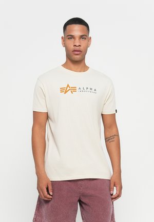 Lichtbeige katoenen t-shirt met een grafisch logo in oranje en grijs. Korte mouwen, ronde halslijn en een ontspannen pasvorm.