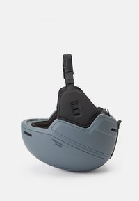 Casco protector en gris mate con un exterior liso, interior acolchado, correa ajustable y aberturas de ventilación en los laterales.