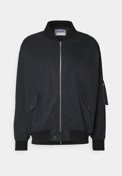 Giacca bomber nera con colletto a coste, zip frontale, tasche laterali e polsini elasticizzati. Realizzata in materiale liscio e leggero.