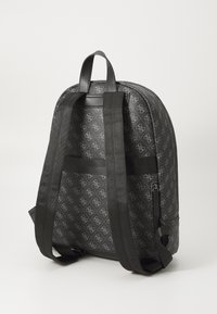 Sac à dos noir avec un motif monogrammé, doté de deux bretelles noires réglables, d'une finition lisse et d'un détail de poche zippée sur le côté.