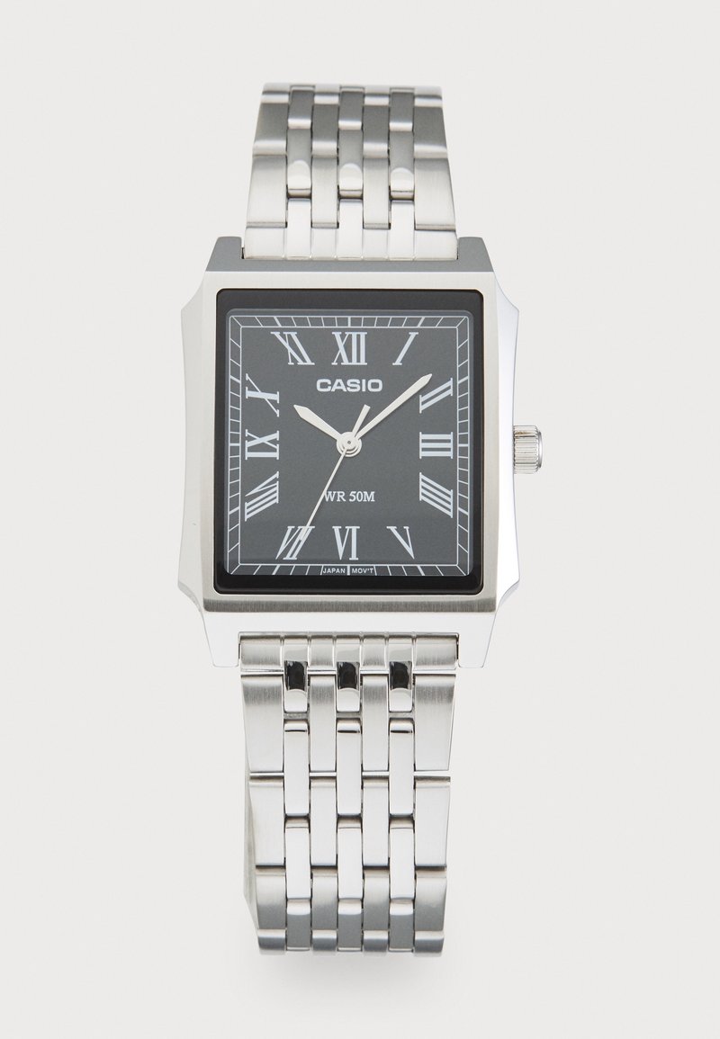 Montre-bracelet Casio argentée avec cadran noir rectangulaire, chiffres romains argentés et bracelet métallique lié, affichant l’heure 10:08:36.
