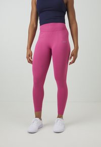 Leggings fuchsia taille haute en tissu texturé, avec un accent logo et une silhouette lisse et ajustée.