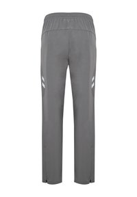 Pantaloni sportivi grigio scuro con taglio affusolato, vita elasticizzata e strisce bianche sulle parti laterali. Caratterizzati da aperture con zip all'orlo.