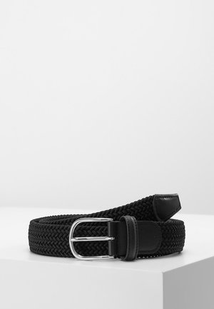 Sort vævet bælte med sølvfarvet metalspænde, læderende og løkke, rullet sammen på et hvidt hjørne.