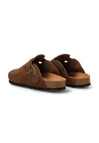 Zapatos marrones de ante tipo slip-on con suela de corcho, que cuentan con una hebilla lateral y un diseño abierto en la parte trasera. Parte superior texturizada y suela de goma.