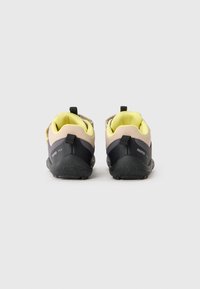 Vue arrière de chaussures pour enfants présentant une combinaison de matériaux rose pâle et gris foncé, un intérieur jaune, une semelle noire texturée et des languettes de tirage.