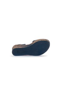 Calzature con una suola in gomma blu scuro, sovrapposta a una intersuola di colore naturale. La suola presenta una superficie testurizzata per migliorare la trazione.