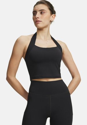 Zwarte halter crop top met een aansluitend ontwerp, gladde textuur en brede bandjes. Gecombineerd met zwart, hoog getailleerd leggings met een naadloze uitstraling.