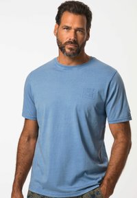 Camiseta de manga corta azul claro, hecha de tela suave, con cuello redondo y un pequeño logo en relieve en el pecho.