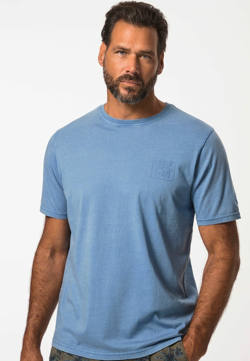 Camiseta de manga corta azul claro, hecha de tela suave, con cuello redondo y un pequeño logo en relieve en el pecho.