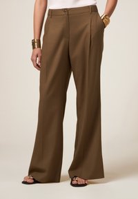 Bruine, op maat gemaakte, wijde broekspijpen hebben een hoge taille, voorplooien en een enkele knoopsluiting, gemaakt van een gladde stof.