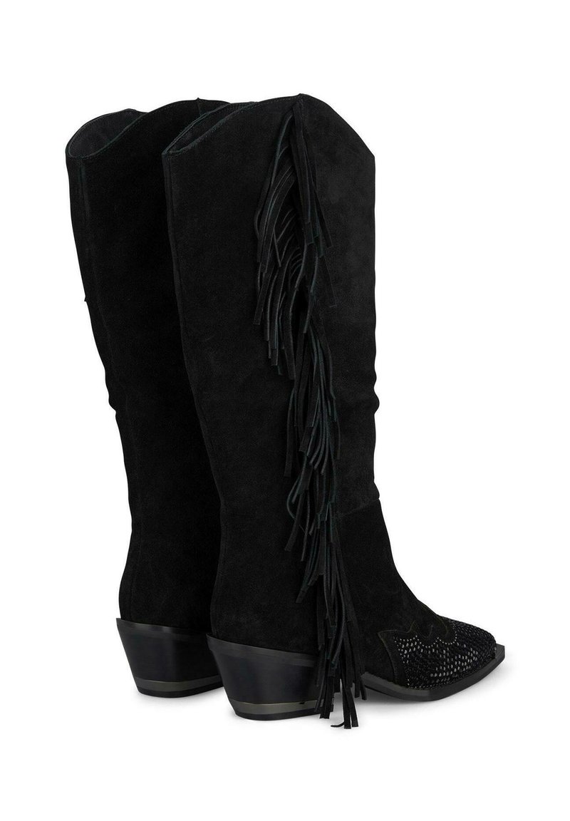 Botas de ante negras hasta la rodilla con flecos en el lateral, diseño de punta afilada y elementos texturizados en la parte frontal. Tacón bajo y apilado.