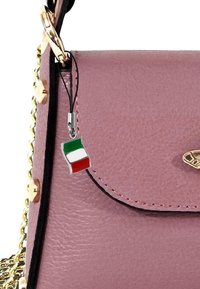 Sac à main en cuir rose avec une fermeture à rabat, quincaillerie dorée, bandoulière en chaîne et un charme en forme de drapeau italien attaché par un cordon noir.
